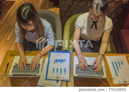 Top view of two business employees working late Top view of two business employees working late 73528950