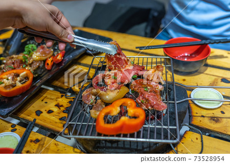 Grilling marinated meat slices and bell pepper on charcoal stove Grilling marinated meat slices and bell pepper on charcoal stove 73528954