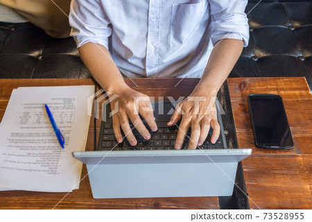 Top view of freelancer hands typing laptop on rustic table Top view of freelancer hands typing laptop on rustic table 73528955