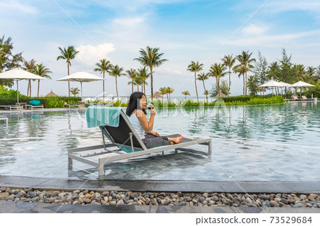 Young Asian woman enjoy red wine at beautiful swimming pool Young Asian woman enjoy red wine at beautiful swimming pool 73529684