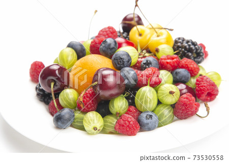 assortment of fresh berries on a white plate. useful vitamin healthy food fruit. assortment of fresh berries on a white plate. useful vitamin healthy food fruit. 73530558