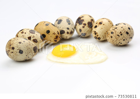 spotted eggs of partridges near the fried eggs on a white background. 73530811