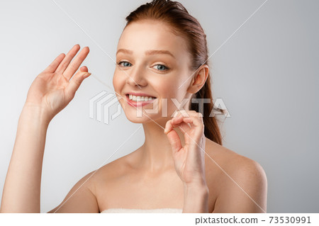 Shirtless Young Woman Flossing Cleaning Teeth Posing Over Gray Background 73530991