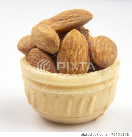 Different nuts in a waffle basket on a white background. Vitamin wholesome food. 73531108