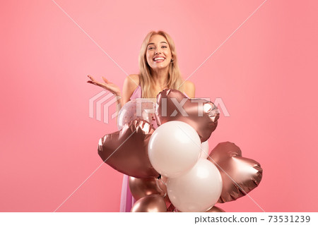 Beauiful young woman with colorful air balloons smiling, having birthday party, pink studio background. Festive concept 73531239