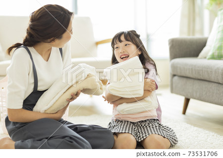 Parent and child folding laundry 73531706