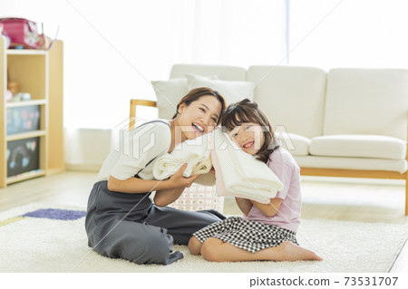 Parent and child folding laundry 73531707