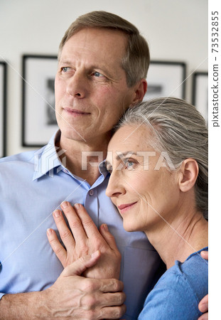 Mature husband embracing smiling middle aged wife, dreaming of good future. Mature husband embracing smiling middle aged wife, dreaming of good future. 73532855