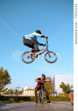 Bmx biker, jump in action, training in skatepark Bmx biker, jump in action, training in skatepark 73533232
