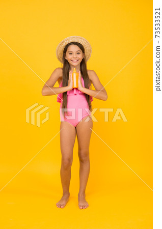 Small girl in swimsuit hold sunscreen cosmetics cream, summer must have concept Small girl in swimsuit hold sunscreen cosmetics cream, summer must have concept 73533521