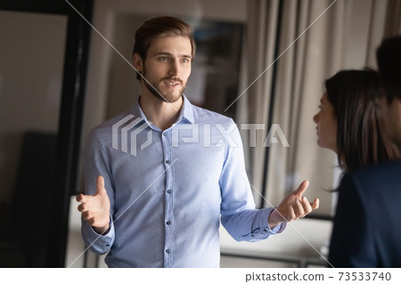 Close up businessman speaking, talking to colleagues at meeting Close up businessman speaking, talking to colleagues at meeting 73533740