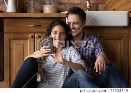Happy man and woman relax using cellphone at home Happy man and woman relax using cellphone at home 73533749