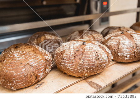 fresh loaves of bread on the shelves in the bakery 73533892