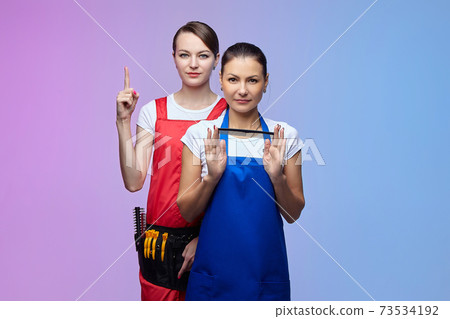 two girls-hairdressers in the studio. Asian and Caucasian appearance. 73534192