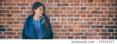 Asian woman banner portrait fashion model wearing autumn outerwear wool waterfall jacket on brick wall office wear style city lifestyle. Panoramic background 73534437