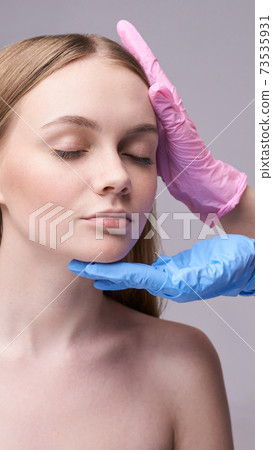 Young pretty woman studio portrait. Cosmetology gloves concept Young pretty woman studio portrait. Cosmetology gloves concept 73535931