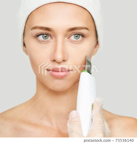 Ultrasonic skin equipment. Woman face cosmetology treatment. Female clinic Ultrasonic skin equipment. Woman face cosmetology treatment. Female clinic 73536140