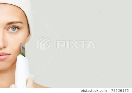 Ultrasonic skin equipment. Woman face cosmetology treatment. Female clinic 73536175