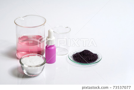 Cosmetic chemicals ingredient on white laboratory table. Potassium Permanganate Liquid, KMnO4, Serum bottle with dropper and Microcrystalline wax in glass container. Cosmetic chemicals ingredient on white laboratory table. Potassium Permanganate Liquid, KMnO4, Serum bottle with dropper and Microcrystalline wax in glass container. 73537077