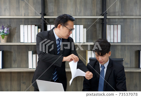 The asian manager blamed the staff and tore the documents apart. Morning work atmosphere in a modern office. The asian manager blamed the staff and tore the documents apart. Morning work atmosphere in a modern office. 73537078