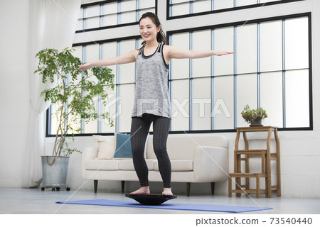 Young women training balance board 73540440