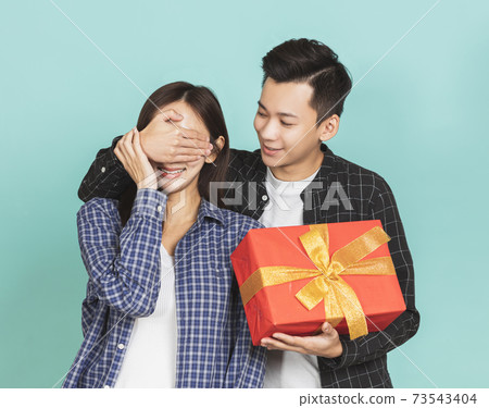 young man giving present to beautiful woman 73543404