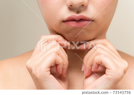Woman pinching her chin Woman pinching her chin 73543756