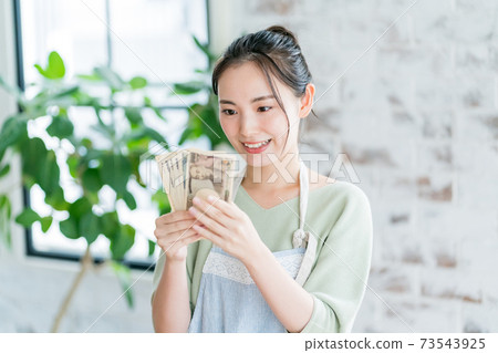 Housewife and wad of bills 73543925