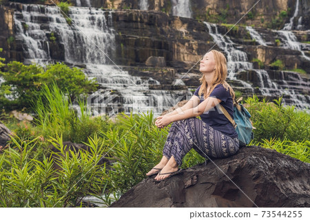 Young woman hiker, tourist on the background of Amazing Pongour Waterfall is famous and most beautiful of fall in Vietnam. Not far from Dalat city estimate 45 Km. Dalat, Vietnam 73544255