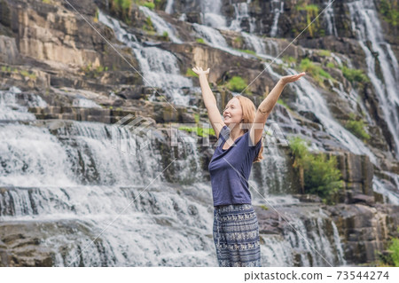 Young woman hiker, tourist on the background of Amazing Pongour Waterfall is famous and most beautiful of fall in Vietnam. Not far from Dalat city estimate 45 Km. Dalat, Vietnam 73544274