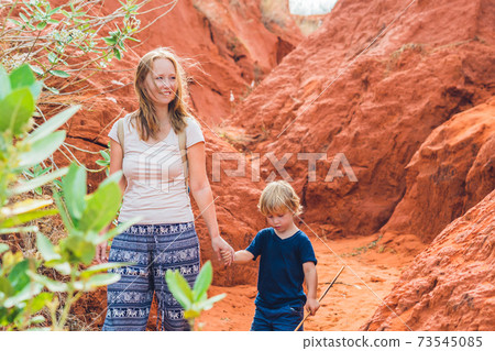 Mother and son travelers in red canyon near Mui Ne, southern Vietnam. Traveling with children concept Mother and son travelers in red canyon near Mui Ne, southern Vietnam. Traveling with children concept 73545085