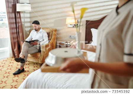 Man reading in hotel room Man reading in hotel room 73545392