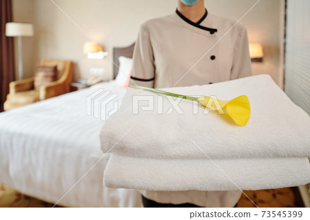 Maid holding fresh towels 73545399