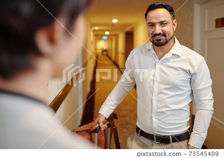 Man talking to hotel manager Man talking to hotel manager 73545409
