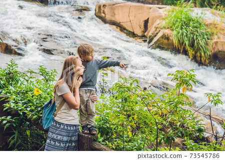 Mother and son on the background of Beautiful Camly waterfall In Da Lat city Mother and son on the background of Beautiful Camly waterfall In Da Lat city 73545786