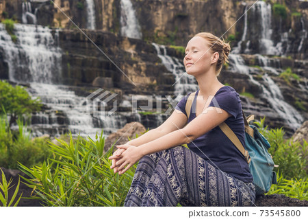 Young woman hiker, tourist on the background of Amazing Pongour Waterfall is famous and most beautiful of fall in Vietnam. Not far from Dalat city estimate 45 Km. Dalat, Vietnam 73545800