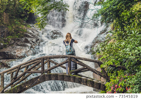 woman in the background of beautiful cascading Datanla waterfall In the mountain town Dalat, Vietnam 73545819