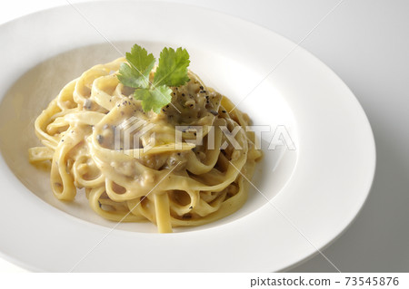 Photographed flat pasta with hot truffle cream with trefoil on a white background 73545876