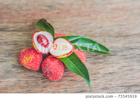 Fresh litchi fruit on an old wooden background Fresh litchi fruit on an old wooden background 73545919