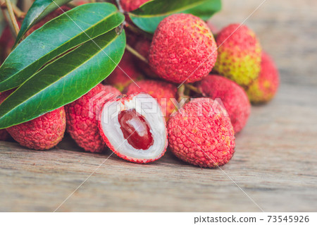 Fresh litchi fruit on an old wooden background Fresh litchi fruit on an old wooden background 73545926