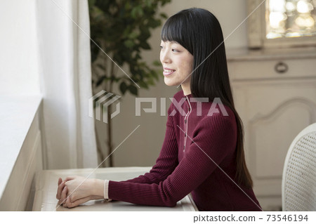 Woman portrait sitting on a chair 73546194