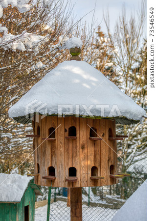 Wooden Dovecote with a roof cowered by snow 73546549