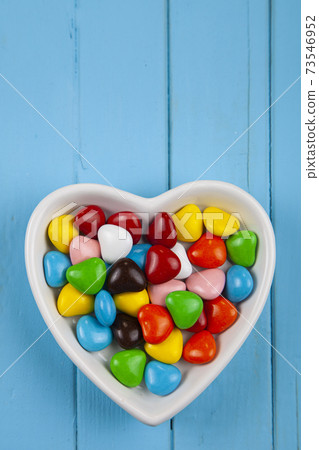 Multicolored candies in a plate in the shape of a heart . Multicolored candies in a plate in the shape of a heart . 73546952