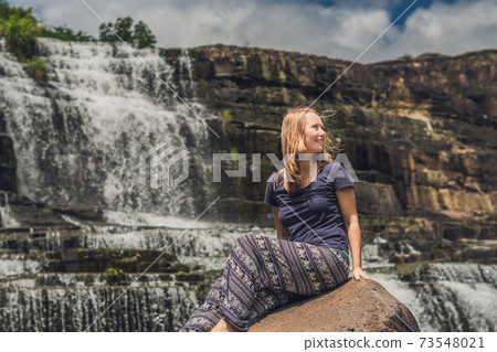 Young woman hiker, tourist on the background of Amazing Pongour Waterfall is famous and most beautiful of fall in Vietnam. Not far from Dalat city estimate 45 Km. Dalat, Vietnam 73548021