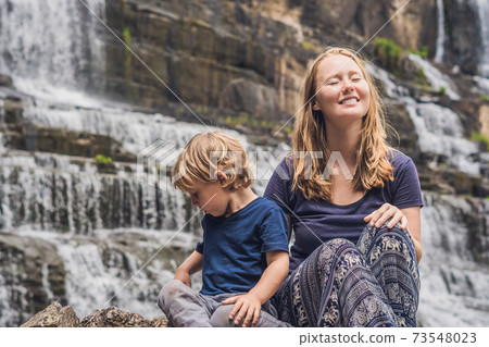 Mother and son hikers, tourists on the background of Amazing Pongour Waterfall is famous and most beautiful of fall in Vietnam. Not far from Dalat city estimate 45 Km. Dalat, Vietnam 73548023