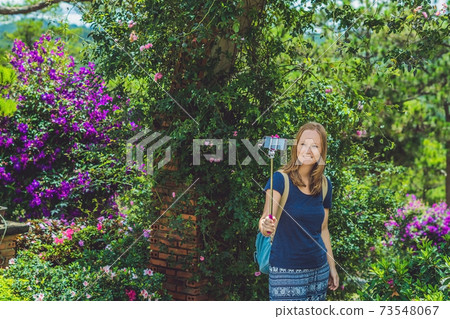young beautiful girl doing selfie mobile phone in the park on summer day 73548067