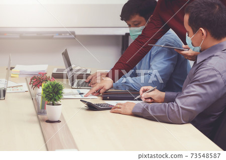 New normal and Social distance conceptual, Employee wearing medical facial mask working in office. New normal and Social distance conceptual, Employee wearing medical facial mask working in office. 73548587