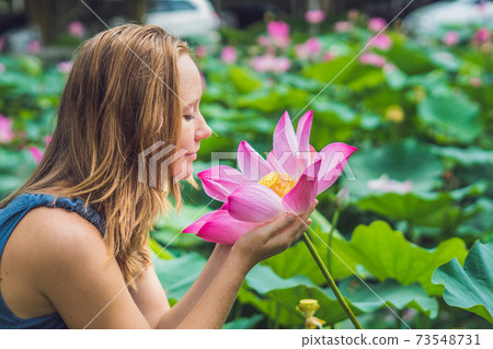 picture of beautiful Red-haired woman with lotus flower in hand picture of beautiful Red-haired woman with lotus flower in hand 73548731
