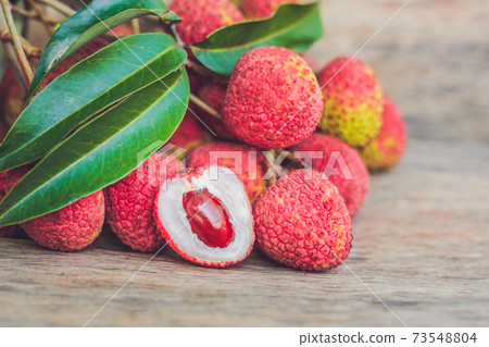 Fresh litchi fruit on an old wooden background Fresh litchi fruit on an old wooden background 73548804