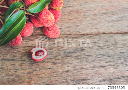 Fresh litchi fruit on an old wooden background Fresh litchi fruit on an old wooden background 73548805
